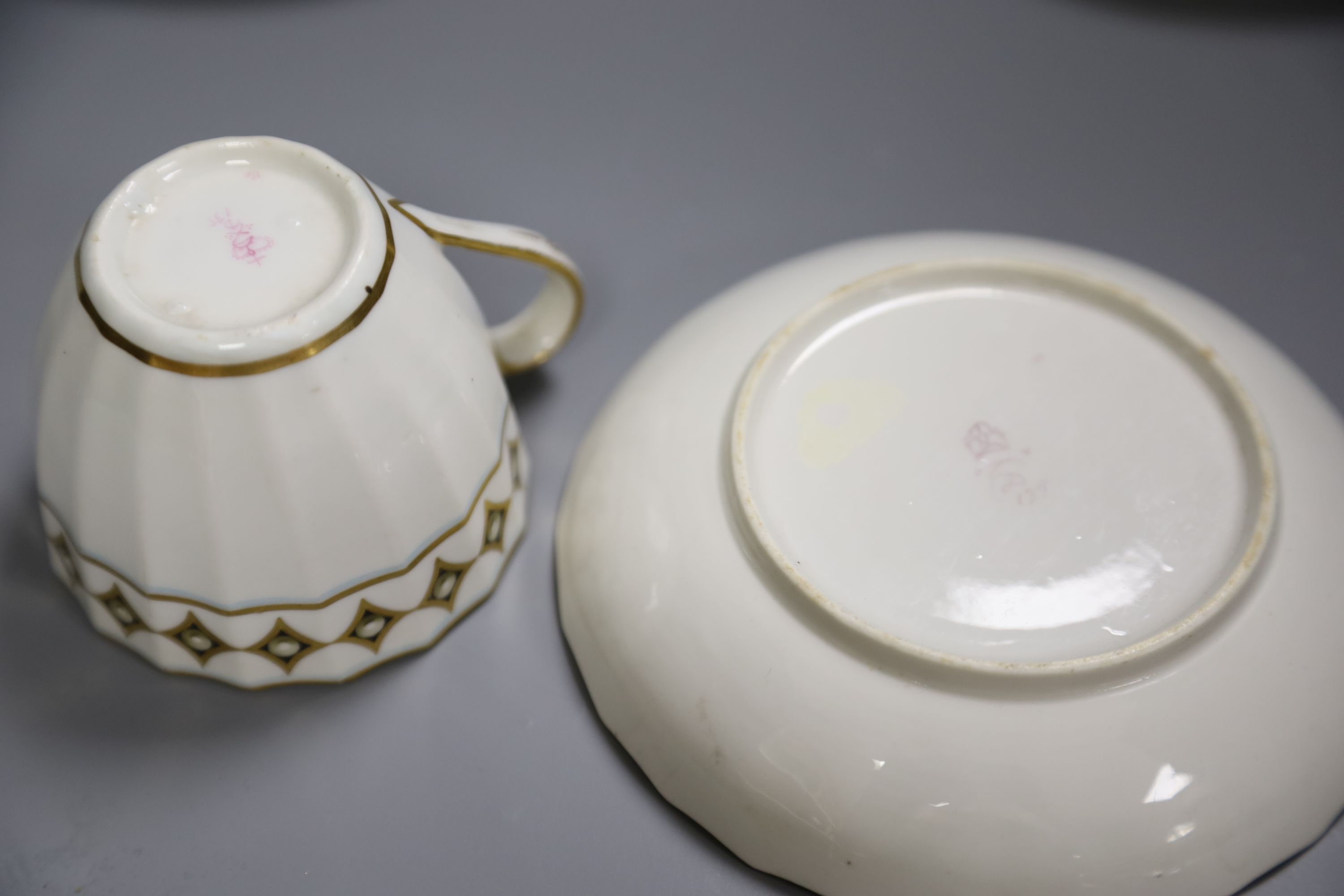 A Derby faceted teacup and saucer painted with pearls on diamond gilding pattern 135 in puce, another similar shaped Derby teacup